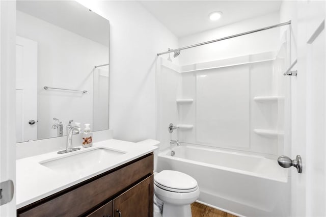 full bathroom featuring vanity, hardwood / wood-style flooring, bathing tub / shower combination, and toilet