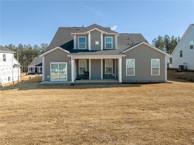 rear view of property with a patio, central AC unit, and a lawn