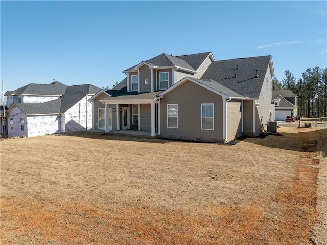 view of front facade with central AC unit, a garage, and a front yard