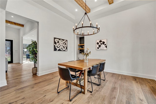 dining area with a notable chandelier, beam ceiling, and light hardwood / wood-style floors