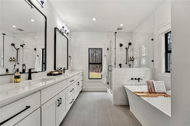 bathroom featuring vanity, a wealth of natural light, and independent shower and bath