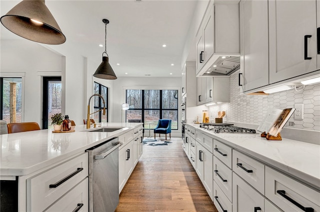 kitchen featuring appliances with stainless steel finishes, sink, white cabinets, and a spacious island