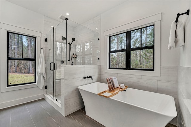 bathroom featuring tile patterned floors, independent shower and bath, and tile walls