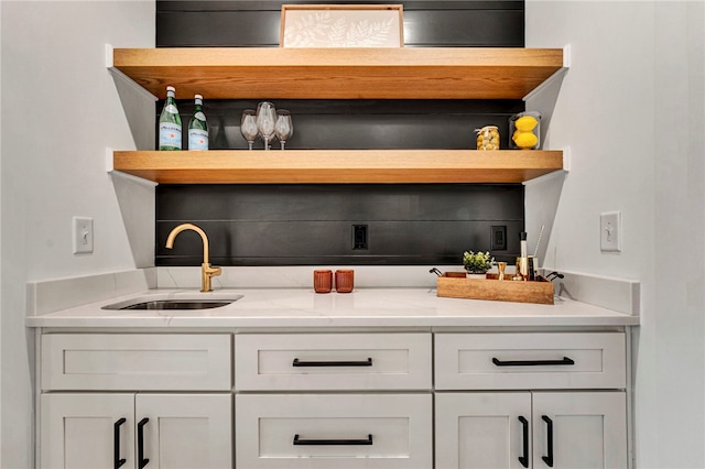 bar featuring white cabinetry and sink