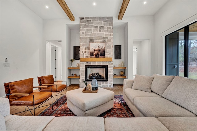 living room with beam ceiling, hardwood / wood-style floors, and a fireplace