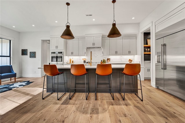 kitchen featuring white cabinetry, a large island, pendant lighting, and appliances with stainless steel finishes