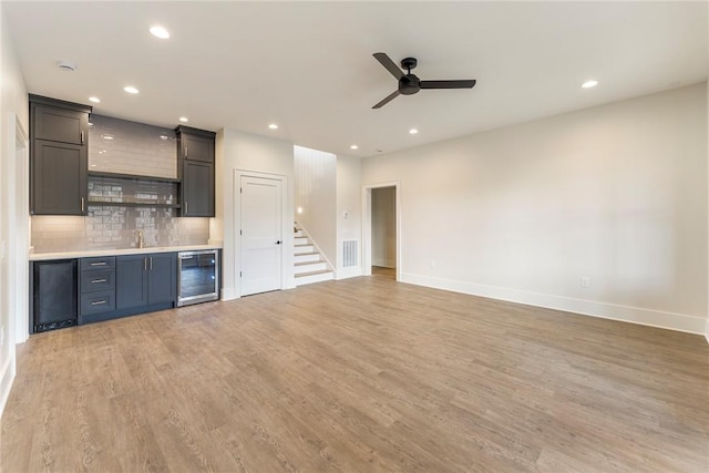 kitchen featuring tasteful backsplash, sink, wine cooler, ceiling fan, and light hardwood / wood-style floors