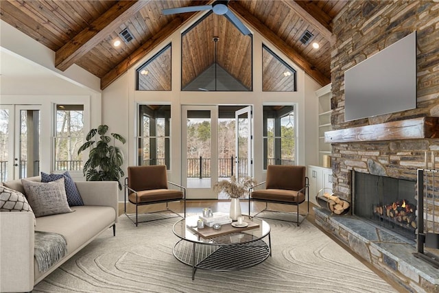 interior space with built in features, a stone fireplace, plenty of natural light, and wooden ceiling