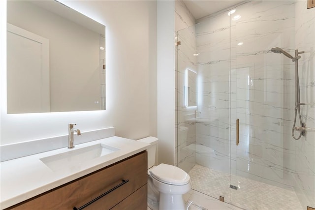 bathroom with vanity, a shower with door, and toilet