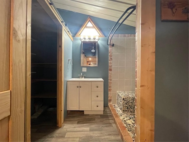 bathroom with vanity, wood-type flooring, and a tile shower