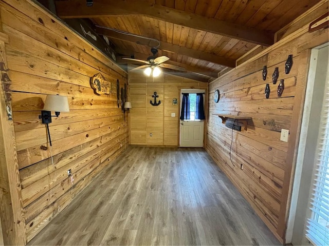 spare room with hardwood / wood-style floors, wooden walls, lofted ceiling with beams, ceiling fan, and wood ceiling