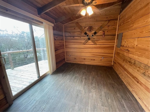 empty room featuring ceiling fan, dark hardwood / wood-style floors, lofted ceiling with beams, wooden ceiling, and wood walls