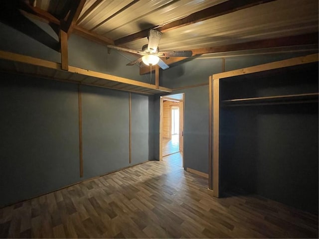 unfurnished bedroom with ceiling fan, wood-type flooring, and beamed ceiling