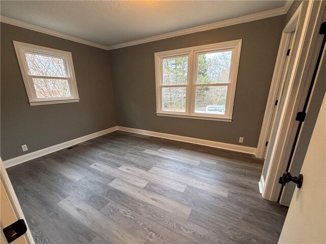 unfurnished room featuring crown molding, plenty of natural light, and dark hardwood / wood-style floors