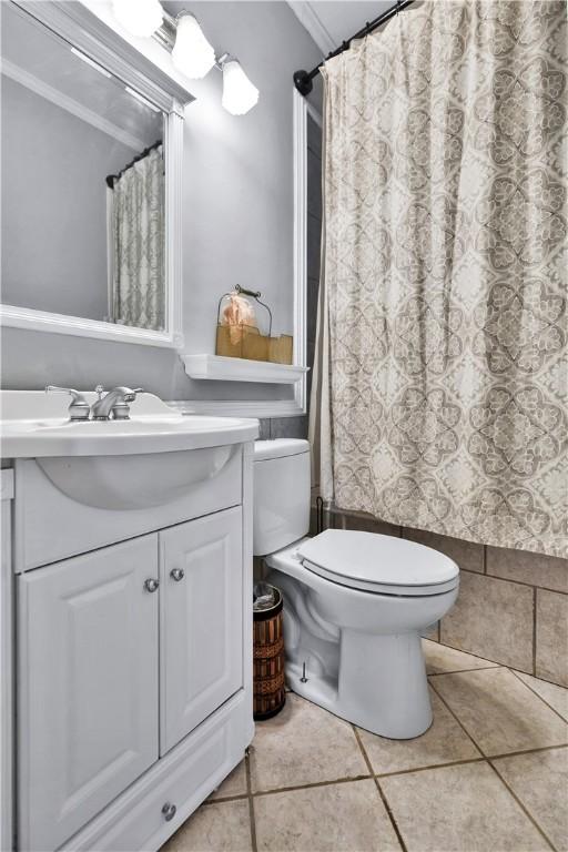 bathroom with vanity, tile patterned flooring, crown molding, and toilet