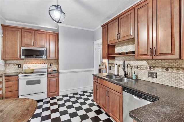 kitchen with appliances with stainless steel finishes, sink, backsplash, hanging light fixtures, and ornamental molding