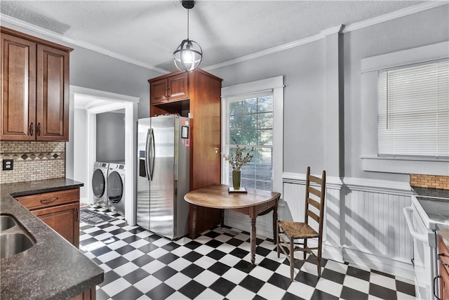 kitchen with decorative light fixtures, separate washer and dryer, ornamental molding, white electric stove, and stainless steel fridge