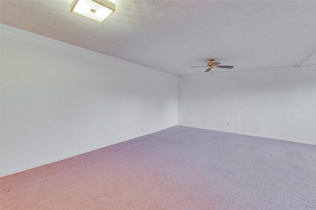 carpeted spare room featuring ceiling fan and a textured ceiling