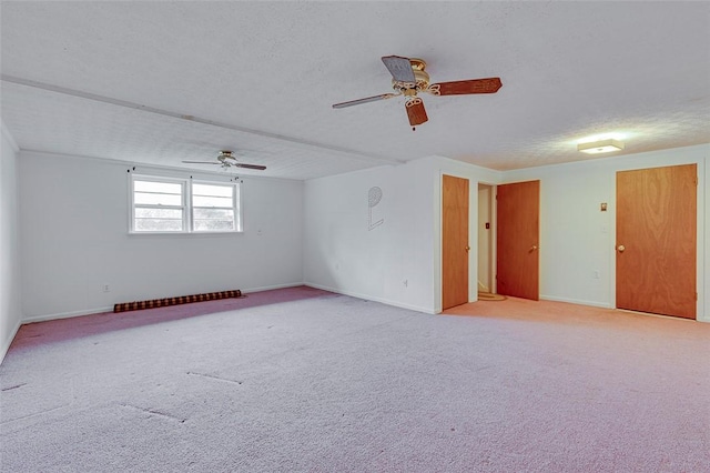 spare room featuring light carpet, ceiling fan, and a textured ceiling