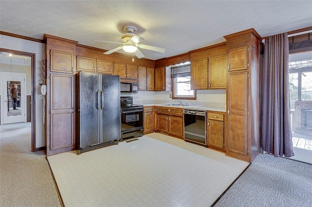 kitchen featuring sink, crown molding, ceiling fan, black appliances, and light colored carpet