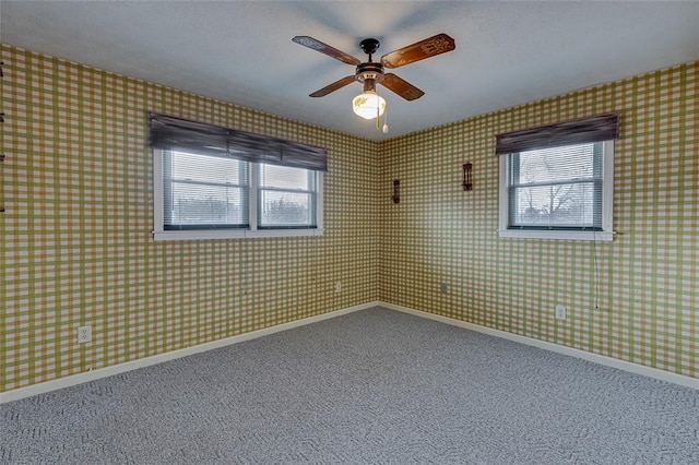 carpeted spare room featuring ceiling fan