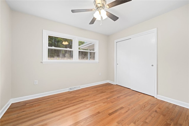 unfurnished bedroom featuring light hardwood / wood-style flooring, a closet, and ceiling fan