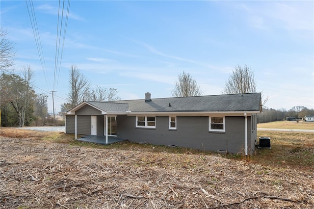 rear view of property with central AC unit and a patio