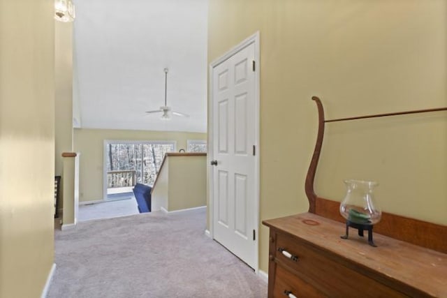 hallway featuring light colored carpet and lofted ceiling