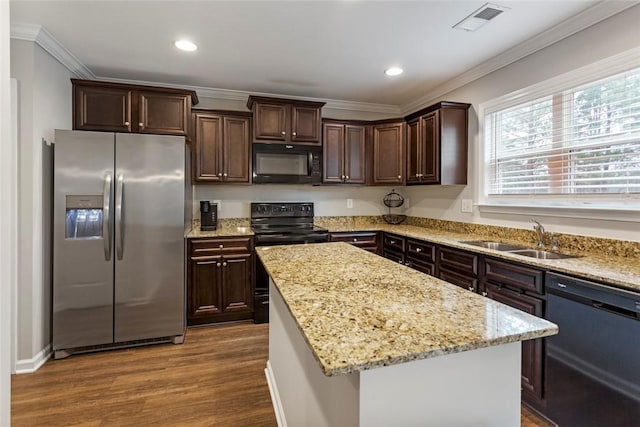 kitchen with sink, ornamental molding, a kitchen island, light stone countertops, and black appliances