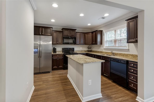 kitchen with sink, dark hardwood / wood-style flooring, a center island, black appliances, and light stone countertops