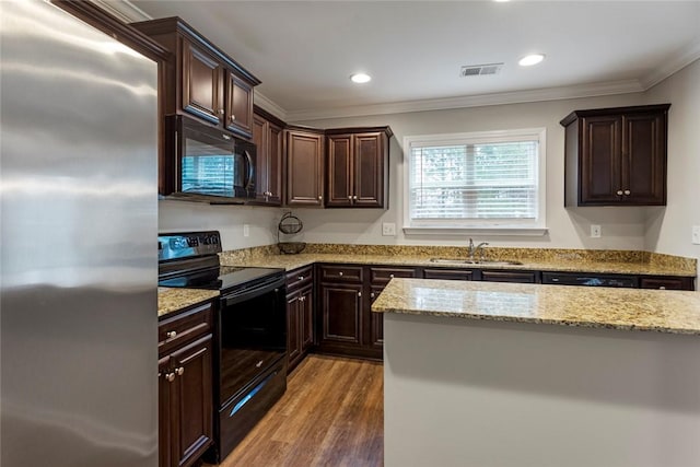 kitchen with hardwood / wood-style floors, sink, black appliances, crown molding, and light stone countertops