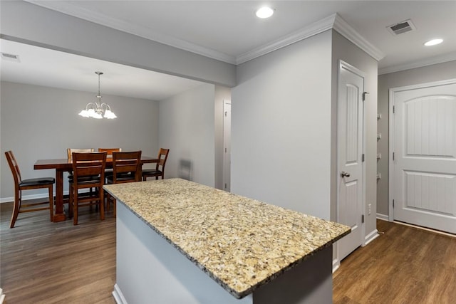 kitchen with pendant lighting, dark hardwood / wood-style flooring, an inviting chandelier, and crown molding