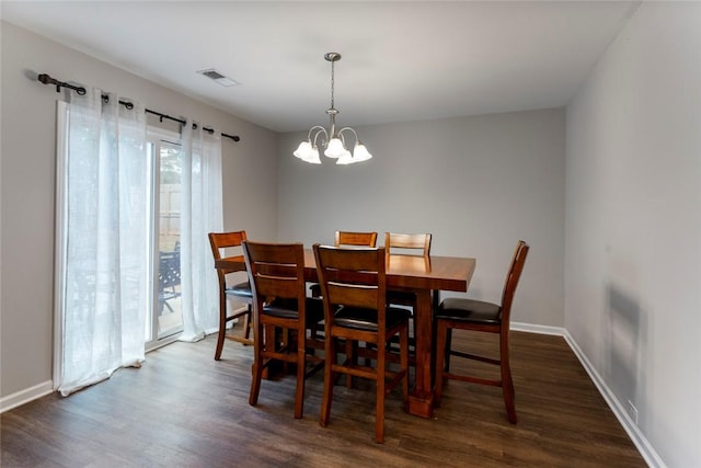 dining area with a notable chandelier and dark hardwood / wood-style floors