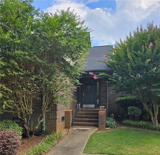 view of property hidden behind natural elements featuring a front yard