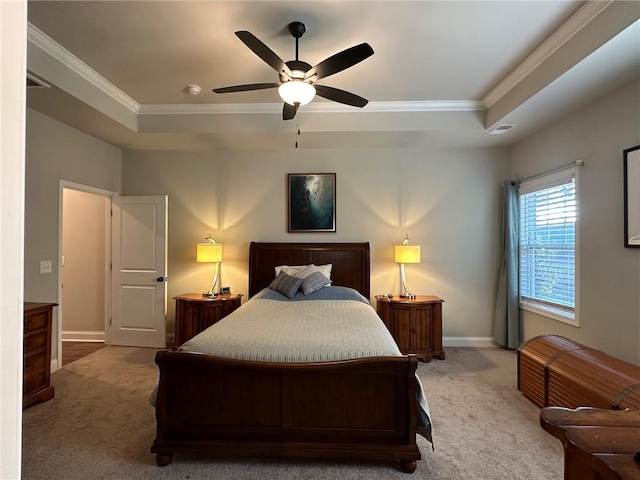 carpeted bedroom with ornamental molding, ceiling fan, and a tray ceiling