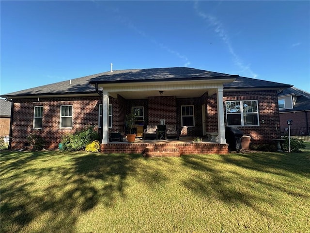 back of property featuring a lawn and a patio area