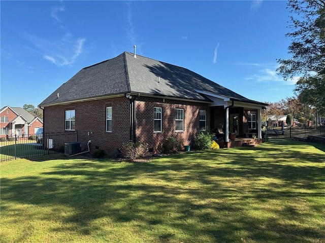 back of property featuring cooling unit and a yard