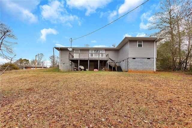 back of property featuring a wooden deck and a yard