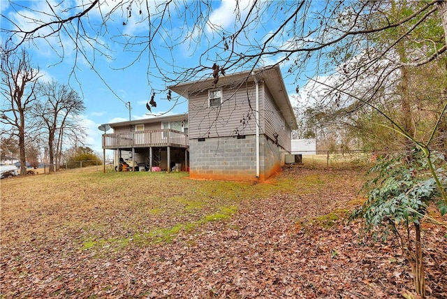 rear view of property with a wooden deck and a lawn