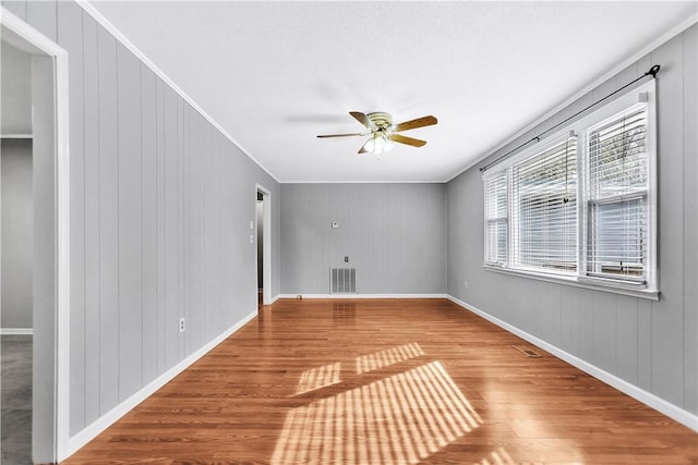 spare room featuring crown molding, ceiling fan, and hardwood / wood-style floors