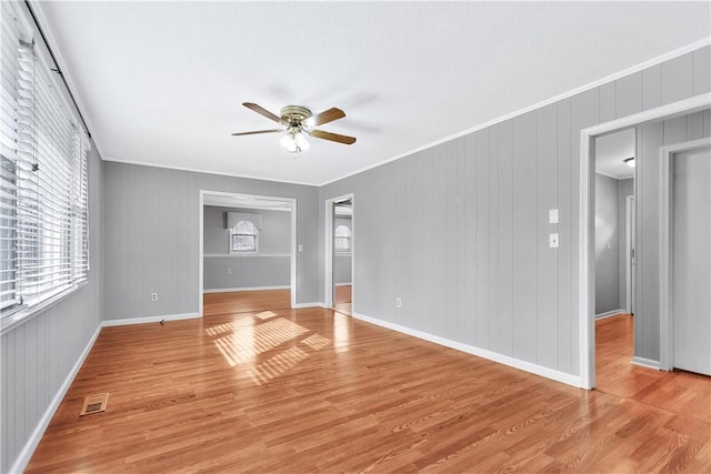 spare room featuring ornamental molding, ceiling fan, and light wood-type flooring