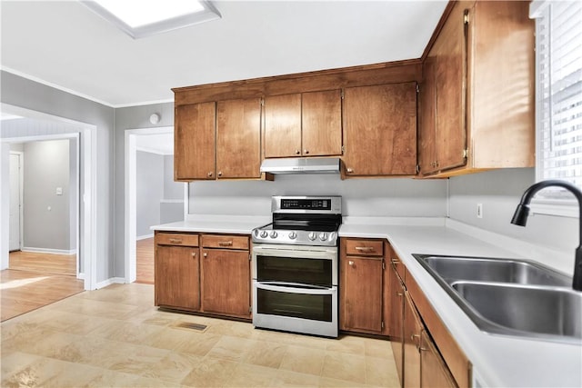 kitchen featuring double oven range, crown molding, and sink