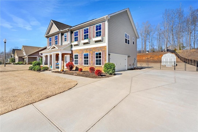 colonial inspired home featuring a garage, a porch, and a storage shed