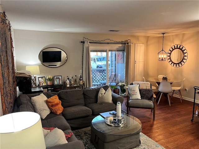 living room featuring dark wood-type flooring and a notable chandelier