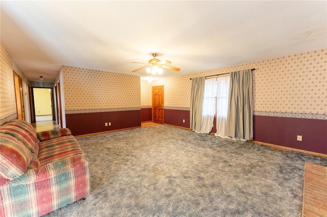 unfurnished living room featuring ceiling fan and carpet