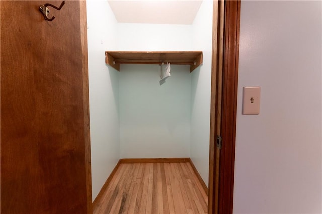 walk in closet with light hardwood / wood-style floors