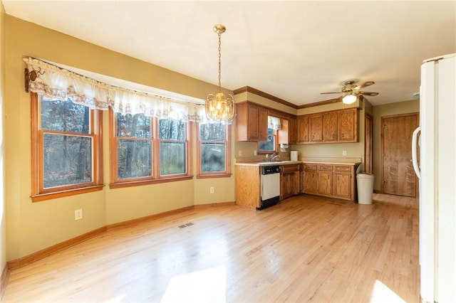 kitchen featuring hanging light fixtures, light hardwood / wood-style flooring, white refrigerator, dishwasher, and a healthy amount of sunlight