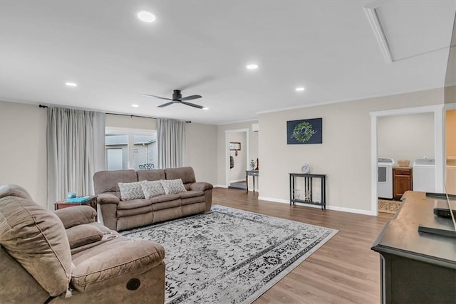 living room featuring ceiling fan, separate washer and dryer, ornamental molding, and light hardwood / wood-style floors