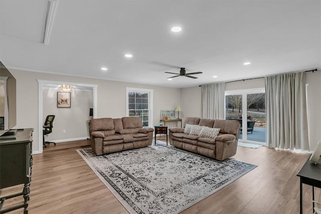 living room featuring crown molding, light hardwood / wood-style flooring, and ceiling fan