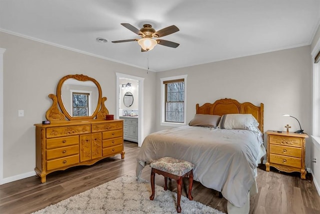 bedroom featuring ornamental molding, dark hardwood / wood-style floors, connected bathroom, and ceiling fan